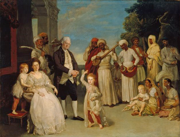 The painting shows a rich white family surrounded by Indian servants and nannies. Some servants carry plates, some play musical instruments. One of the white children is sitting on the lap of an Indian woman. It seems a harmonious and happy scene. From 1783. Painting.