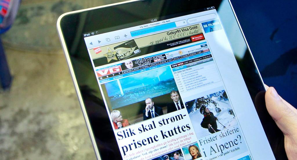 En person som leser nyheter på nettbrett på undergrunnen i Oslo. Foto.