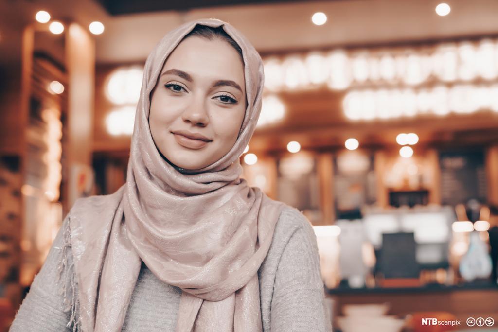 Smilende muslimsk kvinne med hijab. Foto.