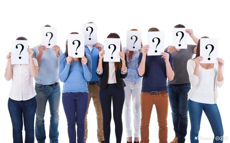 Ei gruppe mennesker holder ark med spørsmålstegn foran ansiktet. Foto.