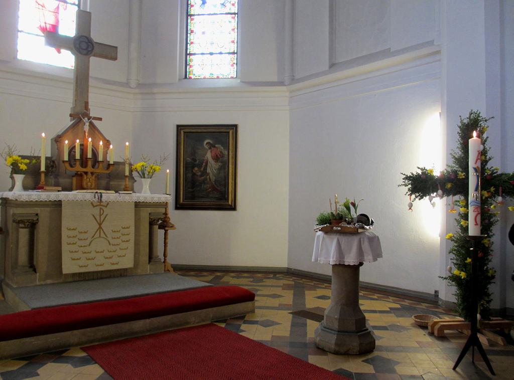 Kirken i Ahlbeck, med påskelys og pyntet kors. Foto. 