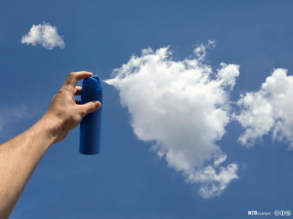 Sprayboks holdes opp mot himmelen slik at det ser ut som en sky sprayes ut. Foto.