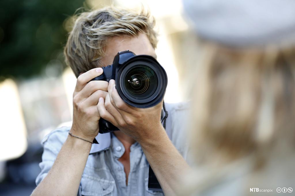 Dame filmer med et digitalt videokamera. Foto.