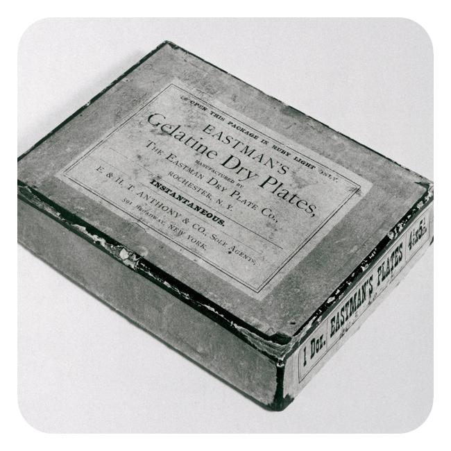 Fotografi som viser ei firkanta eske med påskriften "Eastman's Gelatine Dry Plates". Eska inneholder et dusin plater, og platene er produsert i New York.