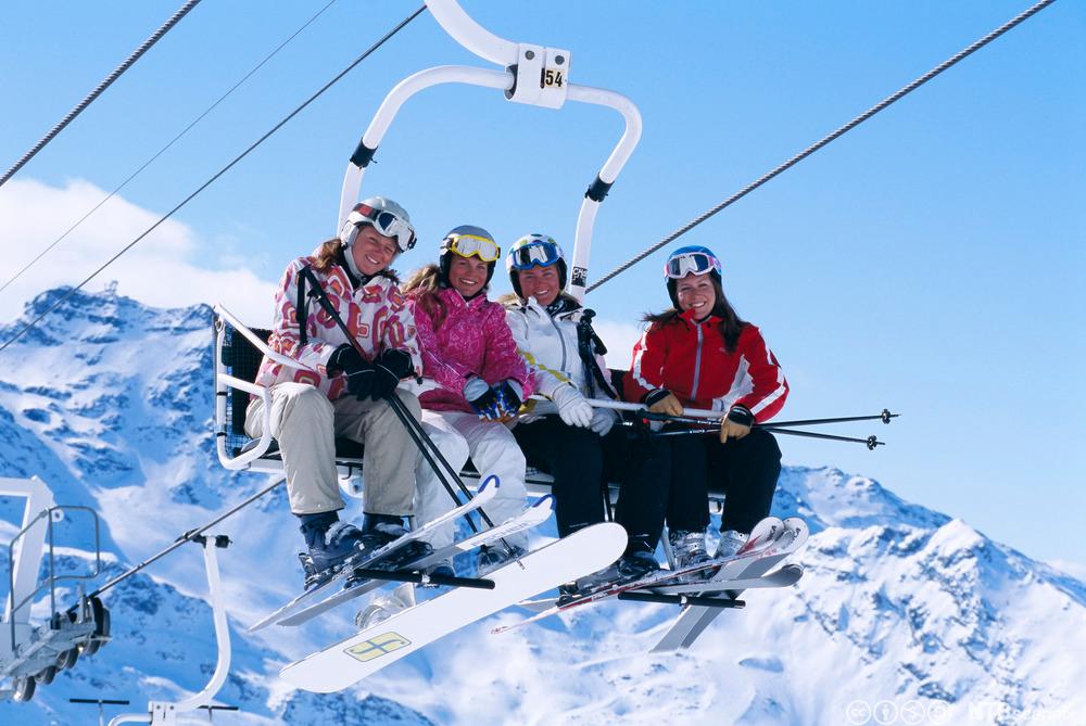 Fire venner sitter  i skiheisen. Foto.