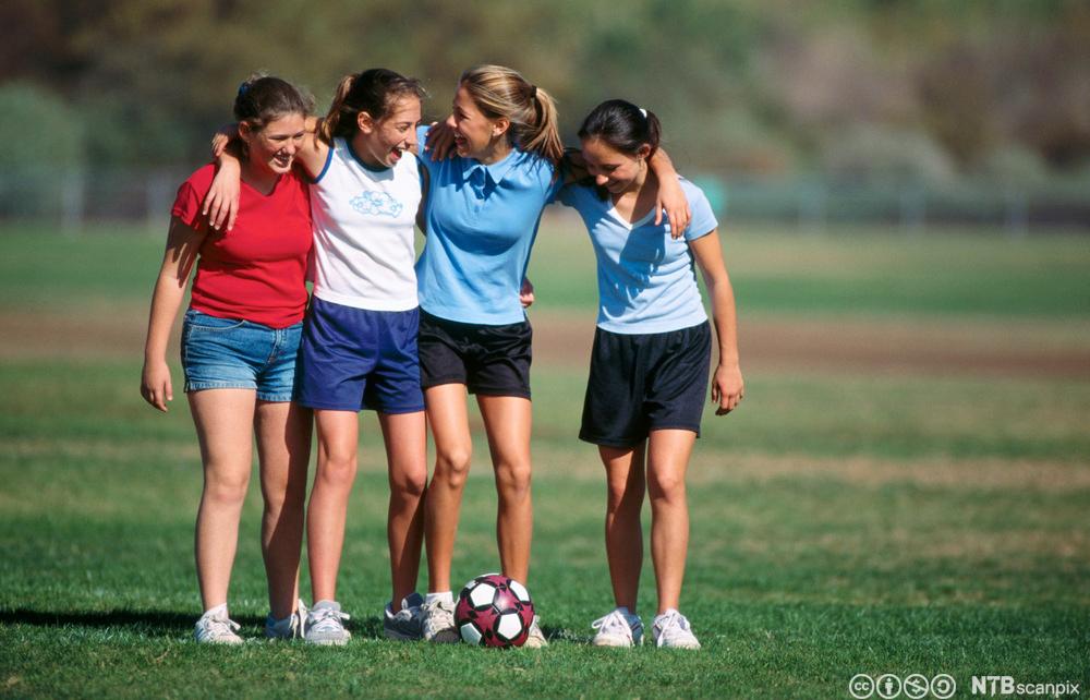 Fire jenter på en fotballbane. Foto.
