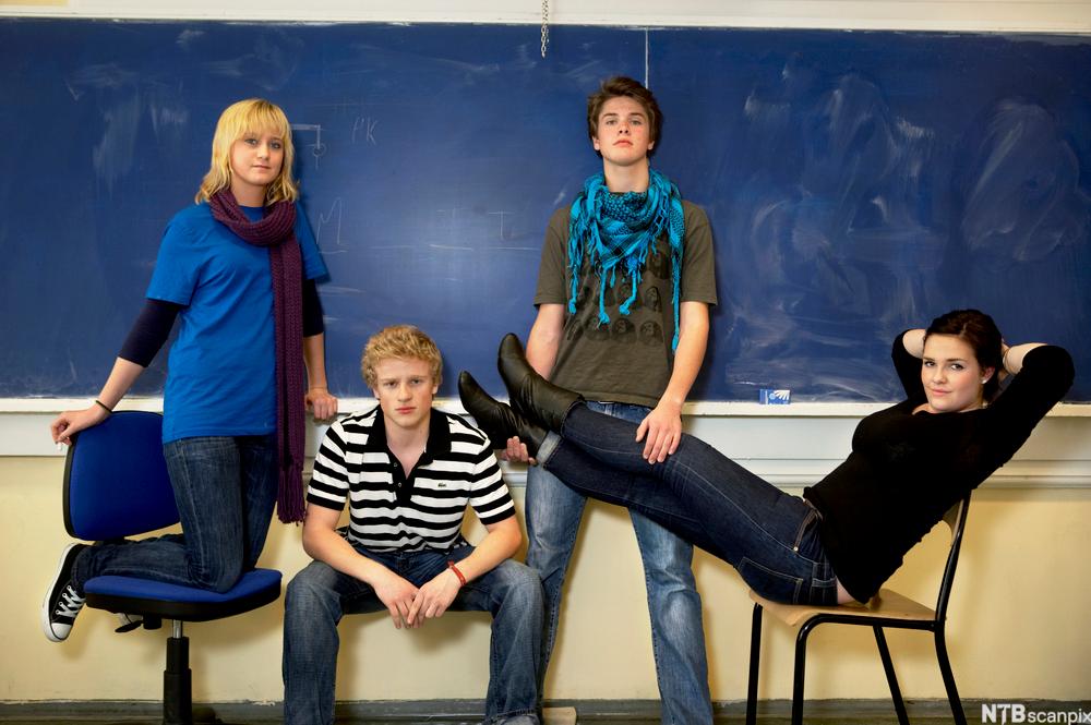 Fire elever poserer foran ei tavle.