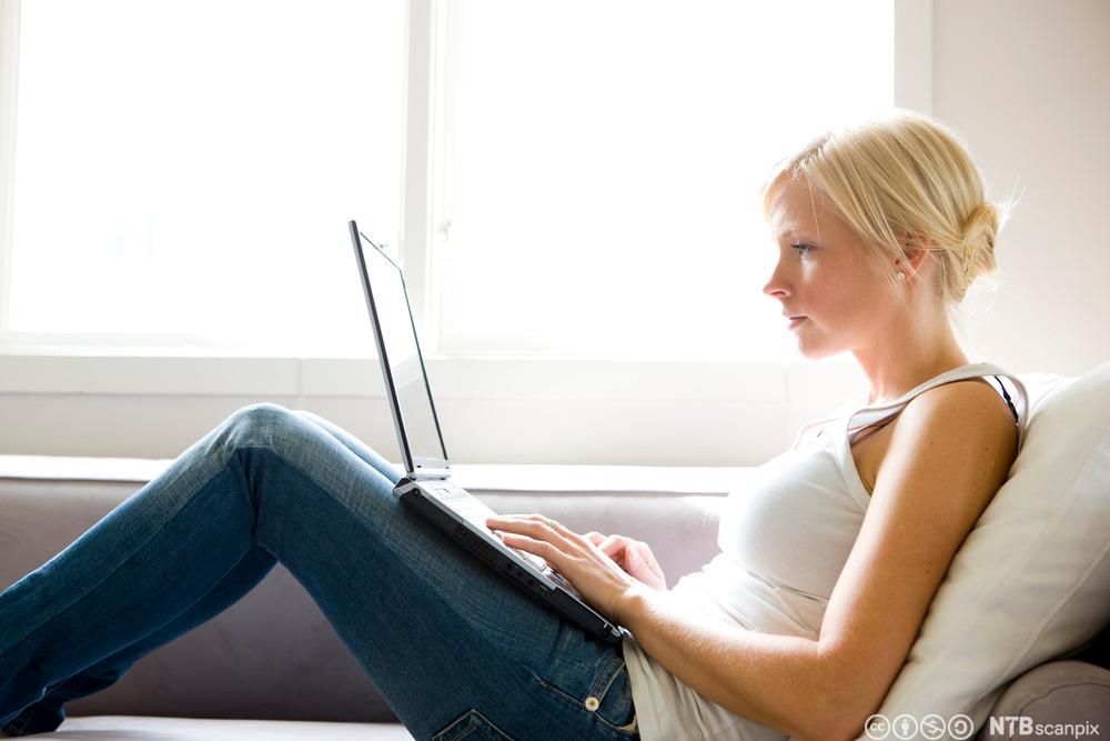 Ung kvinne med laptop. Foto.