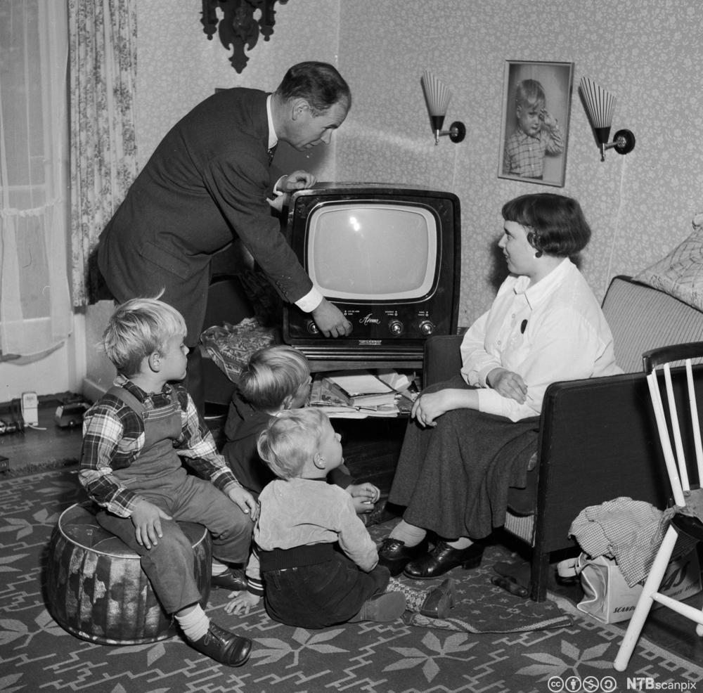 En familie er klar til å se på fjernsyn på slutten av 1950-tallet. Foto.