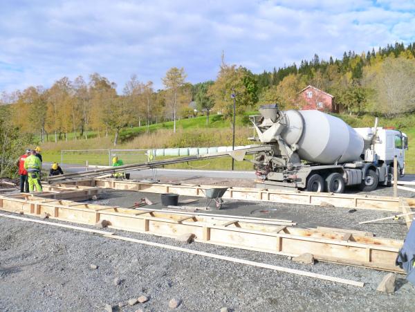 Betongbil leverer betong til forskaling av ringmur. Foto.