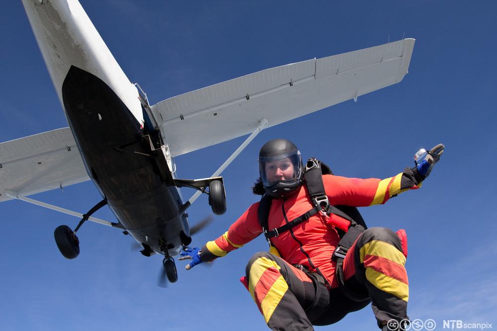 Kvinne hopper i fallskjerm fra et småfly. Foto.