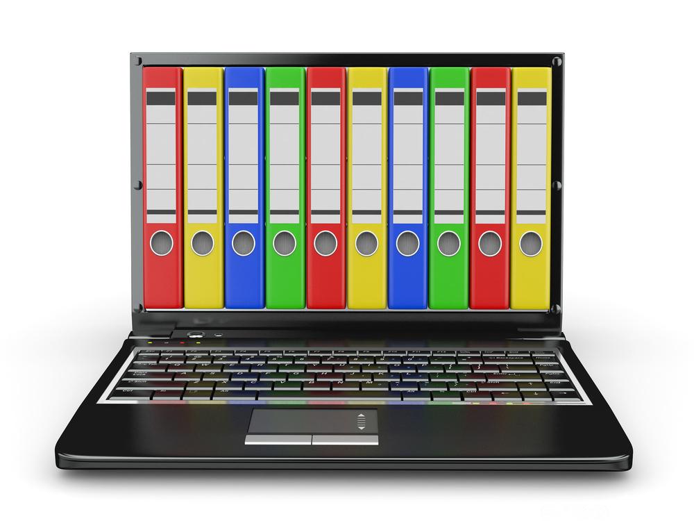 Bærbar datamaskin med ringpermrygger i ulike farger over hele skjermen. Foto.
