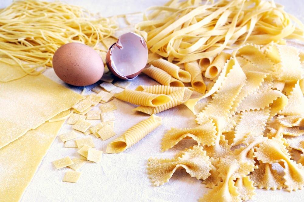 Ulike pastatyper og et egg på et bord. Foto.