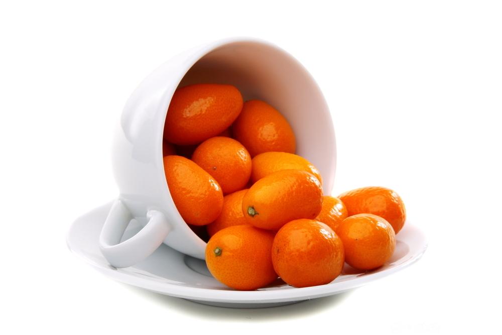 Fleire kumquat i ein velta kopp. Foto.
