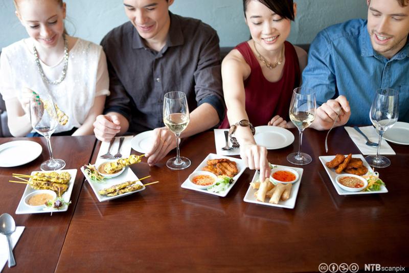 Fire venner spiser mat på restaurant. Foto.
