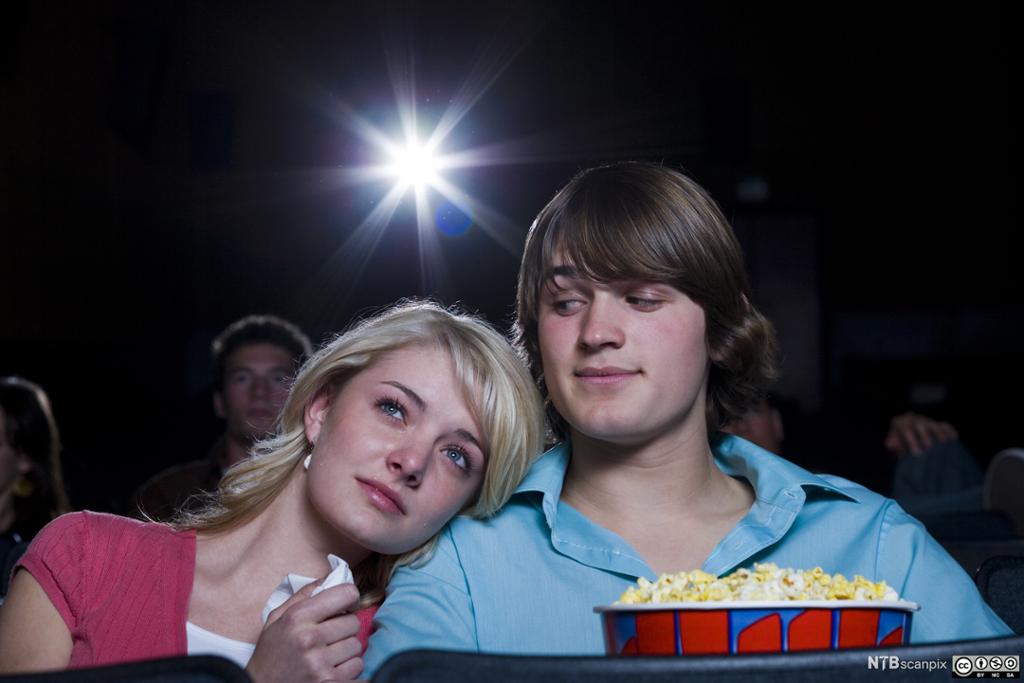 Kjærestepar på kino med popcorn. Foto.
