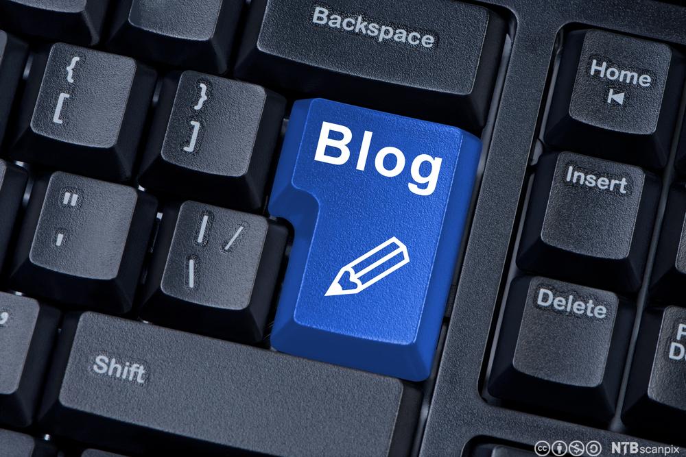 Foto med nærbilde av et svart tastatur, der Enter-tasten er blå og har påtrykt teksten "Blog" og et blyantsymbol.