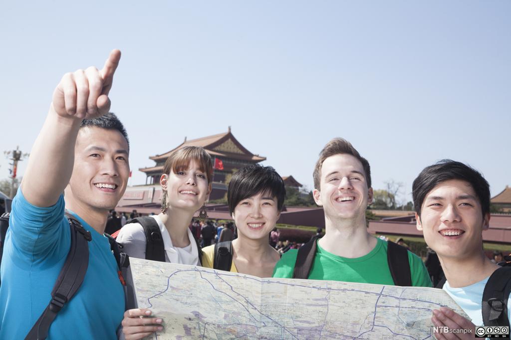 En gruppe unge mennesker i Beijing ser på kart. Foto.
