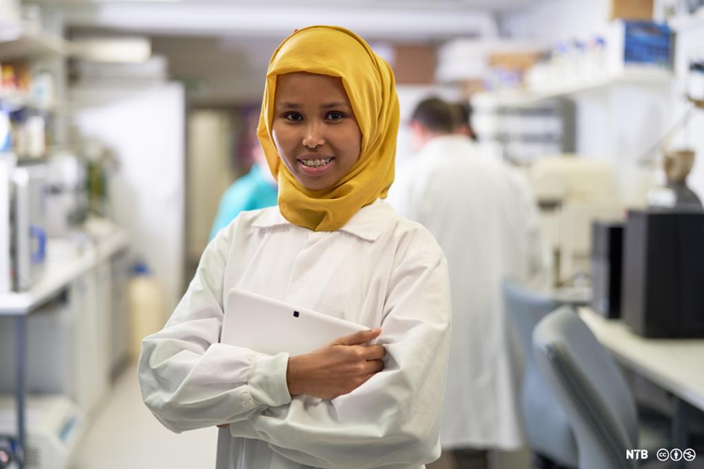 Ung forsker i lab-frakk og hijab. Foto.