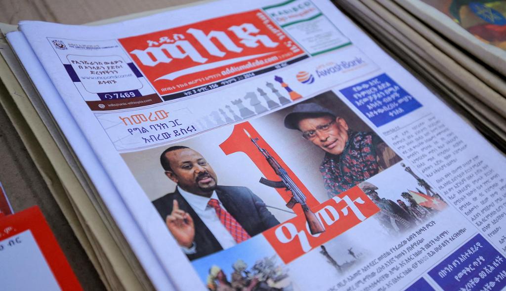 Portrettbilete av Etiopias statsminister Abiy Ahmed og leiar av Tigray-folkets frigjeringsfront (TPLF) Debretsion Gebremichael på framsida av ei etiopisk avis. Statsministeren er avbilda i dress og slips, mens TPLF-leiaren har kaps og skjerf. Mellom dei to portretta er det bilete av eit gevær. Foto.