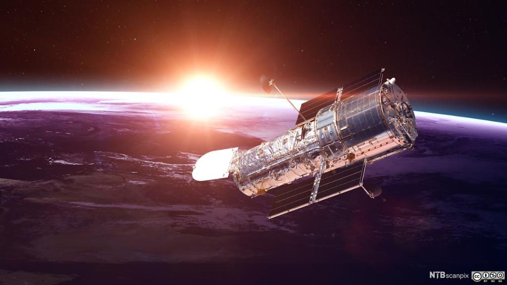 Hubble-teleskopet med jorda og sola i bakgrunnen. Foto.