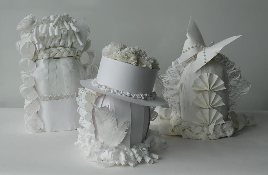 Tre dekorative parykker laget av papir. Foto.