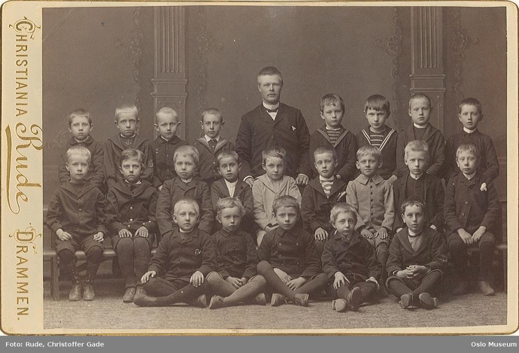 Klassefotografi av små gutter med en lærer i midten. Foto.
