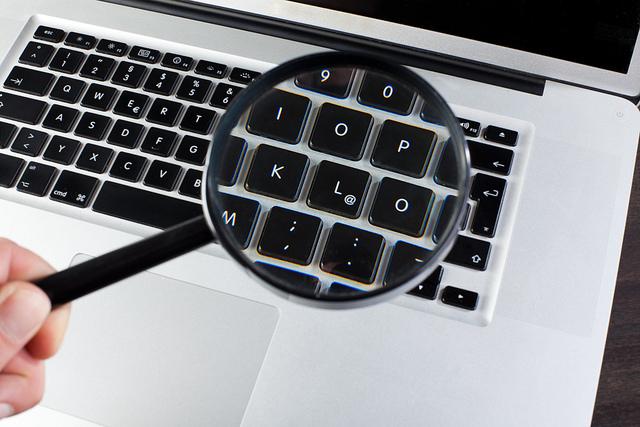 Forstørrelsesglass over et pc-tastatur. Foto.