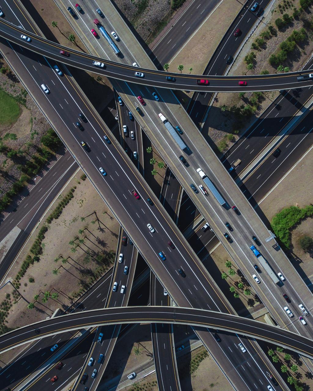 Luftfoto av et travelt motorveikryss fullt av trafikk på dagtid. Foto.