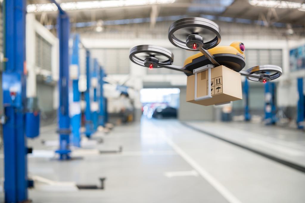 En drone flyr med en pakke i en hall. Foto.