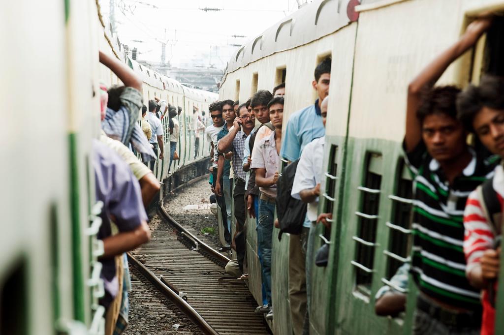 En stor mengde passasjerer på tog fra forstedene til Kolkata (Calcutta) i India. Foto.