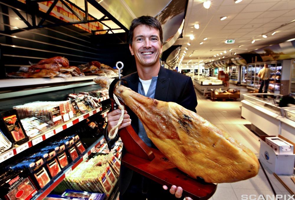 Ole Robert Reitan viser frem spekeskinke. Foto.