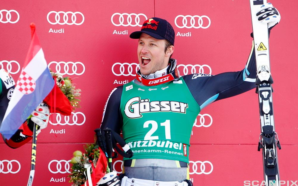 Bilde av Aksel Lund Svindal på seierspallen, med reklame for Audi i bakgrunnen.