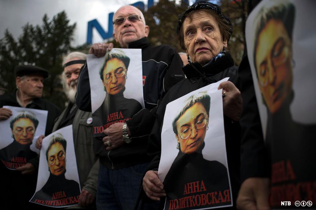 Demonstrantar held opp plakatar med bilete av Anna Politkovskaja. Foto.