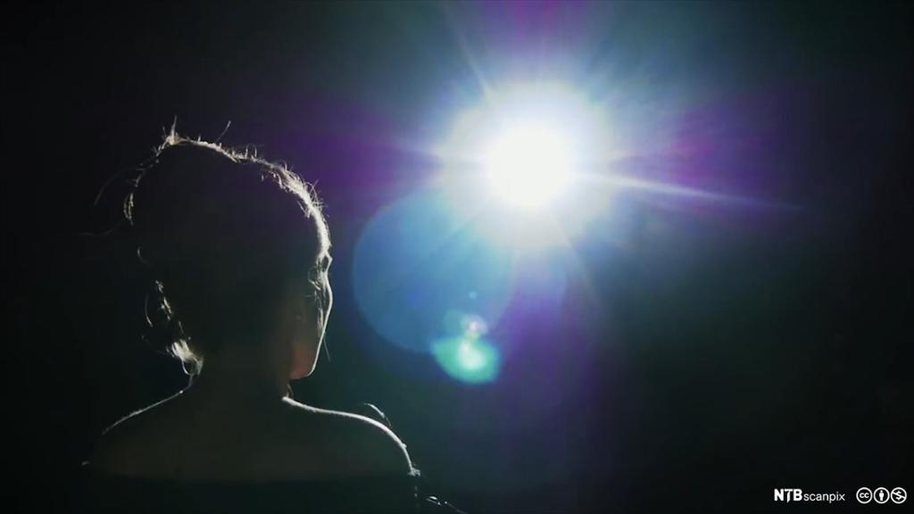 Actress standing in the spotlight.