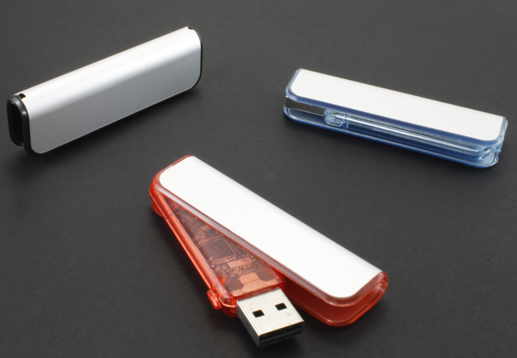 Tre USB-minnepenner ligger på en overflate. Foto.