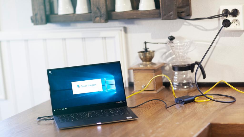 PC på kjøkkenbenken med kaffeutstyr i bakgrunnen.  På skjermen vises Windows Server Manager. Foto.