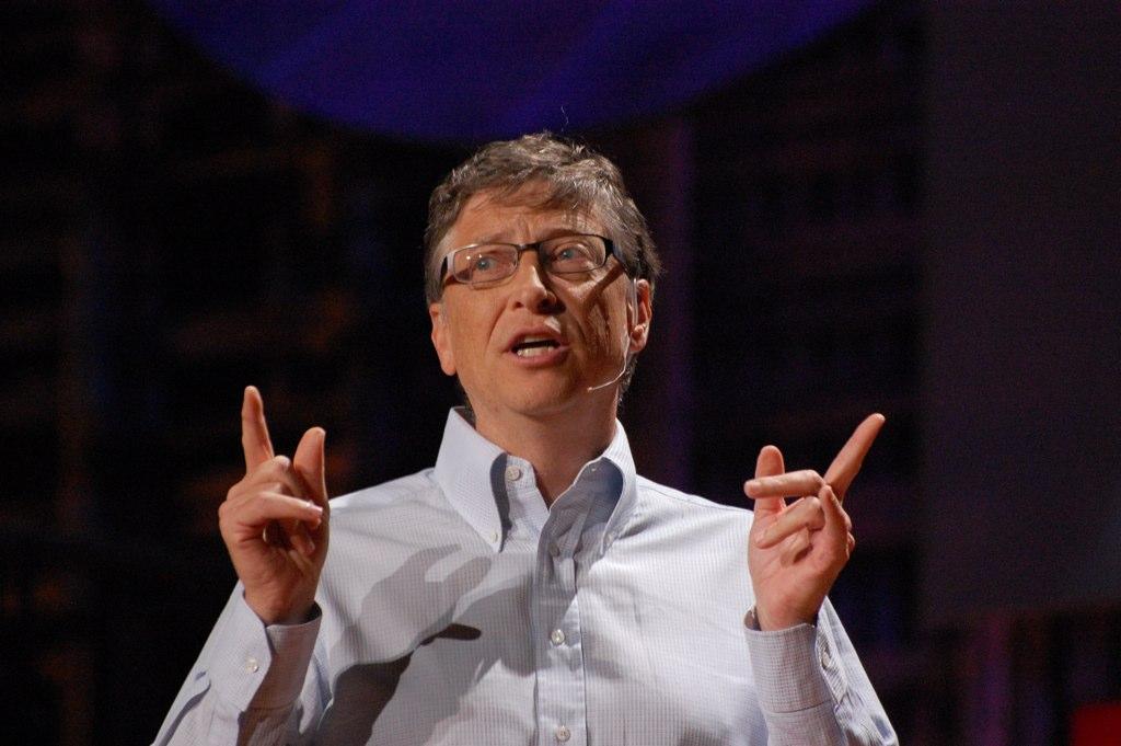 A close-up photo of Bill Gates, gesturing with his hands while talking to an audience. 