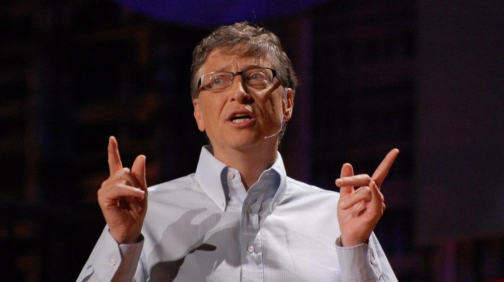 A close-up photo of Bill Gates, gesturing with his hands while talking to an audience. 