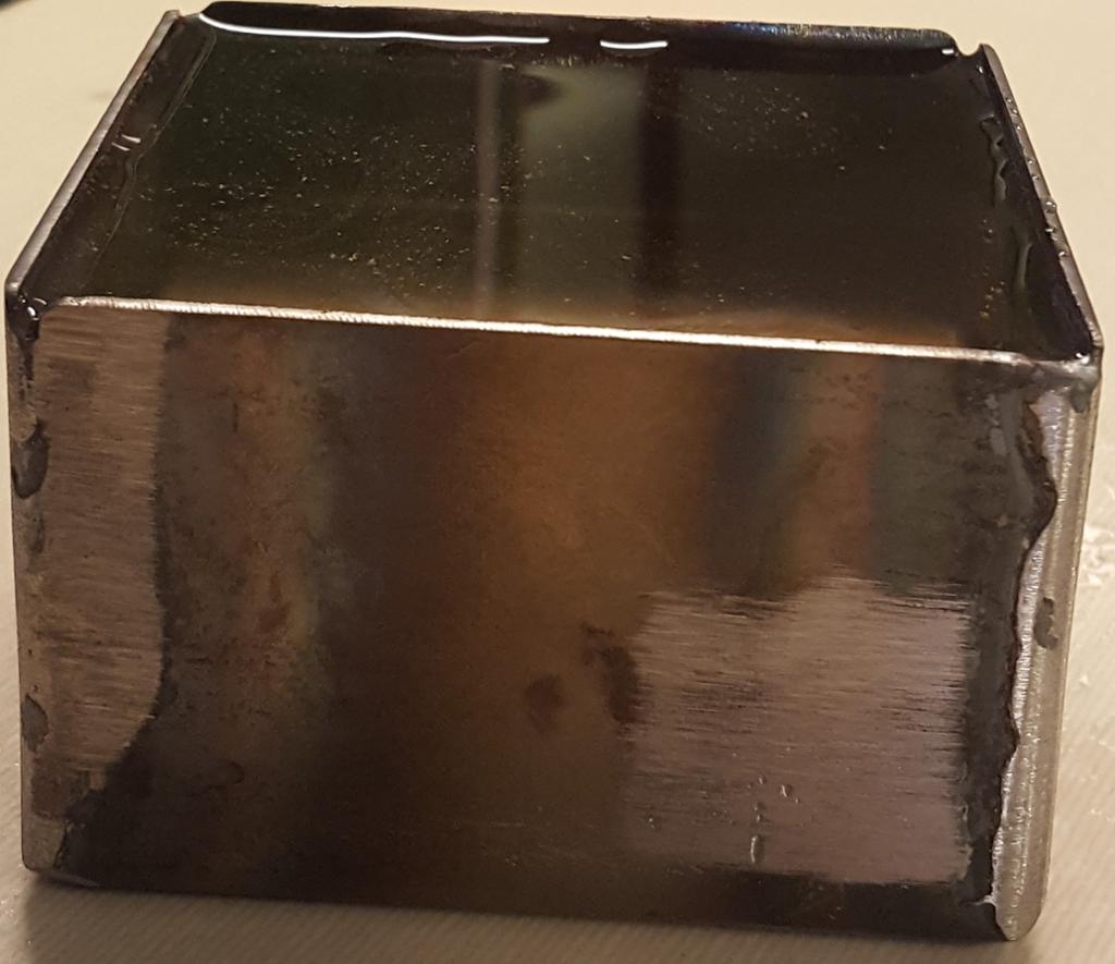 Ein sveisa metallboks er fylt med vatn og ser ut til å vere tett. Foto.