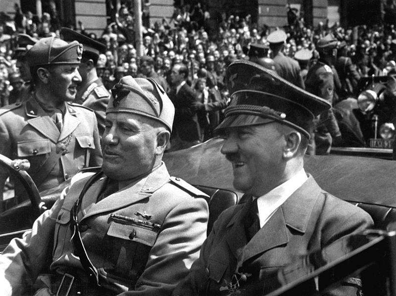 Benito Mussolini og Adolf Hitler køyrer saman i ein open bil i Munchen i 1940. Foto.  