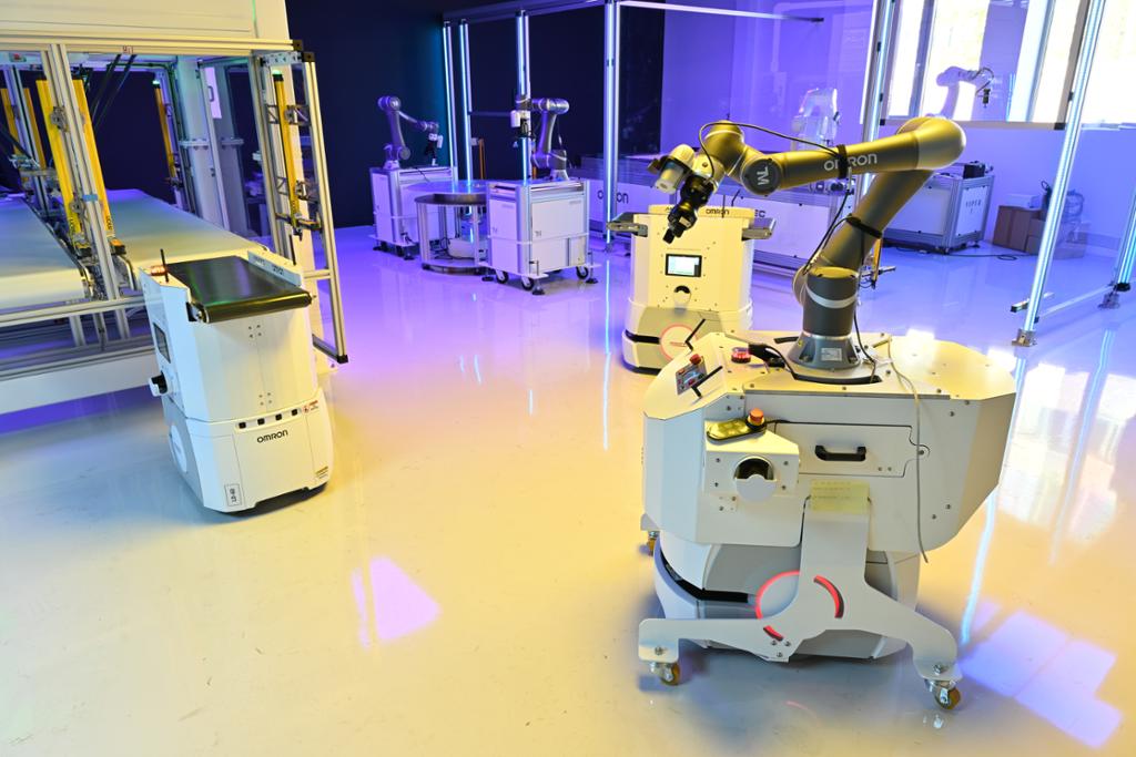 Samarbeidande robot i forskningslaboratoriet Manulab. Fleire robotar i bakgrunnen. Foto.