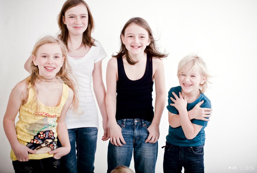Fire barn som ligner som søsken. Tre jenter og en gutt i ulik alder. Alle smiler. Foto.