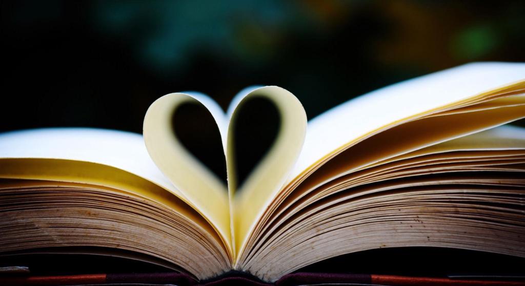 Photo of an open book where two pages are folded so that it makes the shape of a heart. 