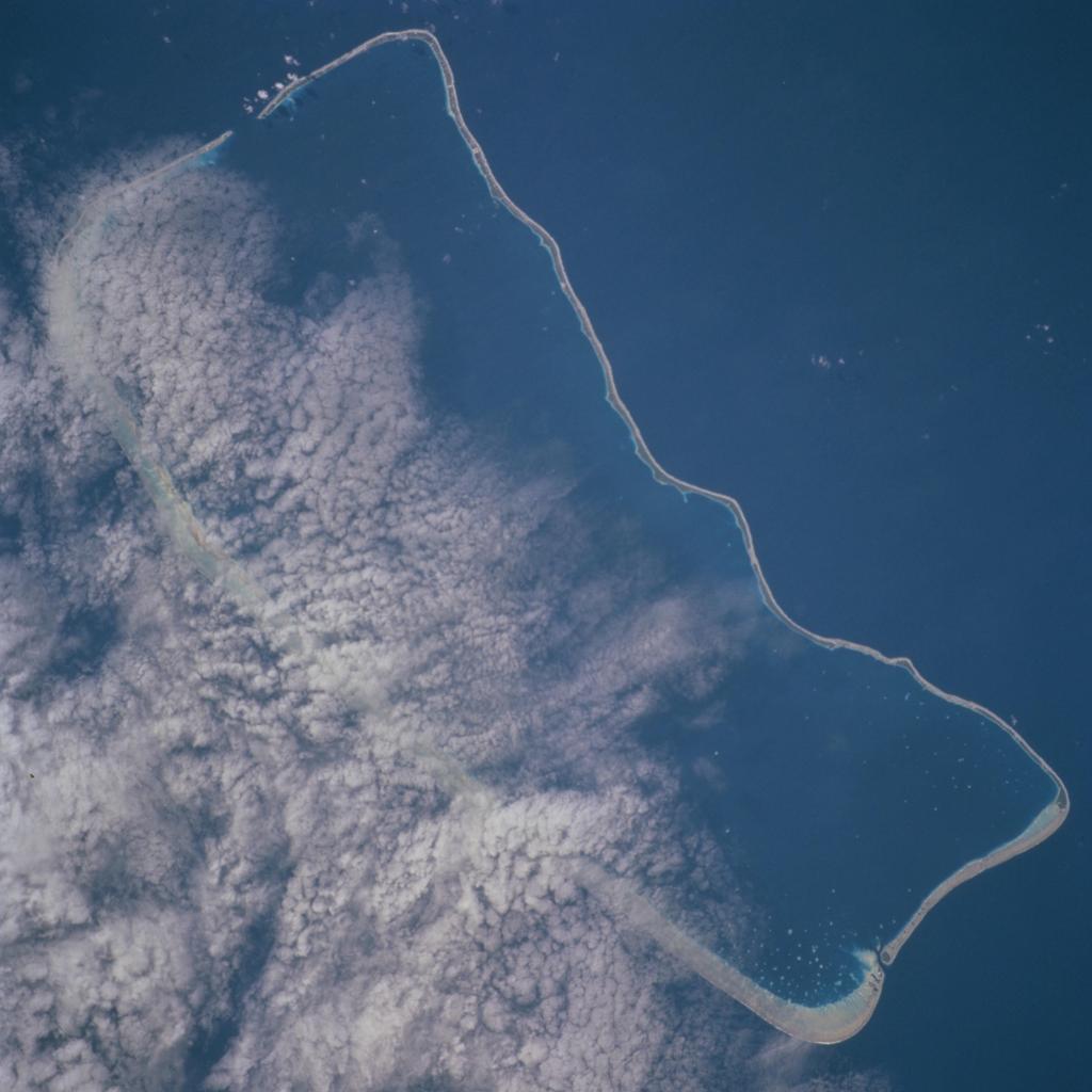 Atoll som ligger rundt en stor lagune, fotografert ovenfra. Foto.