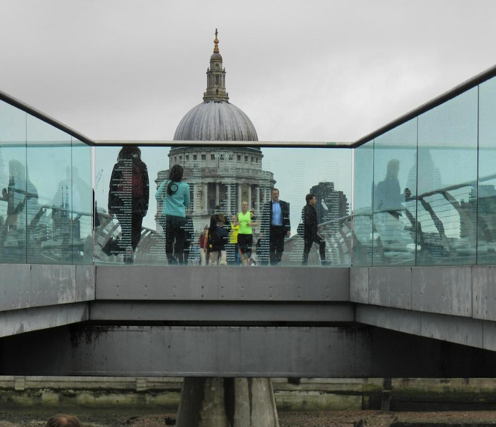 People walking on a bridge, St. Paul's Cathedral in the background. 