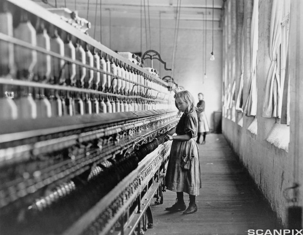 En ung jente i arbeid på et bomullsspinneri i Nord-Carolina i 1908. Foto.