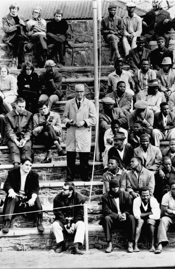 The segregated stands of a sports arena in Bloemfontein, South Africa, with white people on one side of the stand and blacks on the other. Back / white photo.