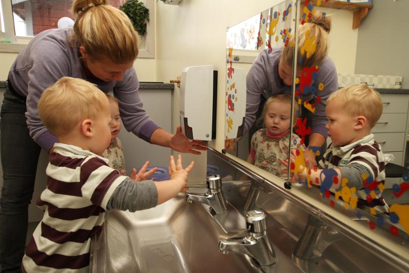 Barn som vasker hendene. Foto.