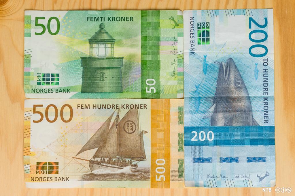 Foto av tre norske pengesetlar: ein femtilapp med fyrtårn, ein femhundrelapp med ei redningsskøyte og ein tohundrelapp med ein torsk.